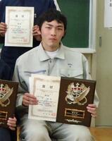 ・表彰状と北海道科学大学から贈呈された盾を持つ林君